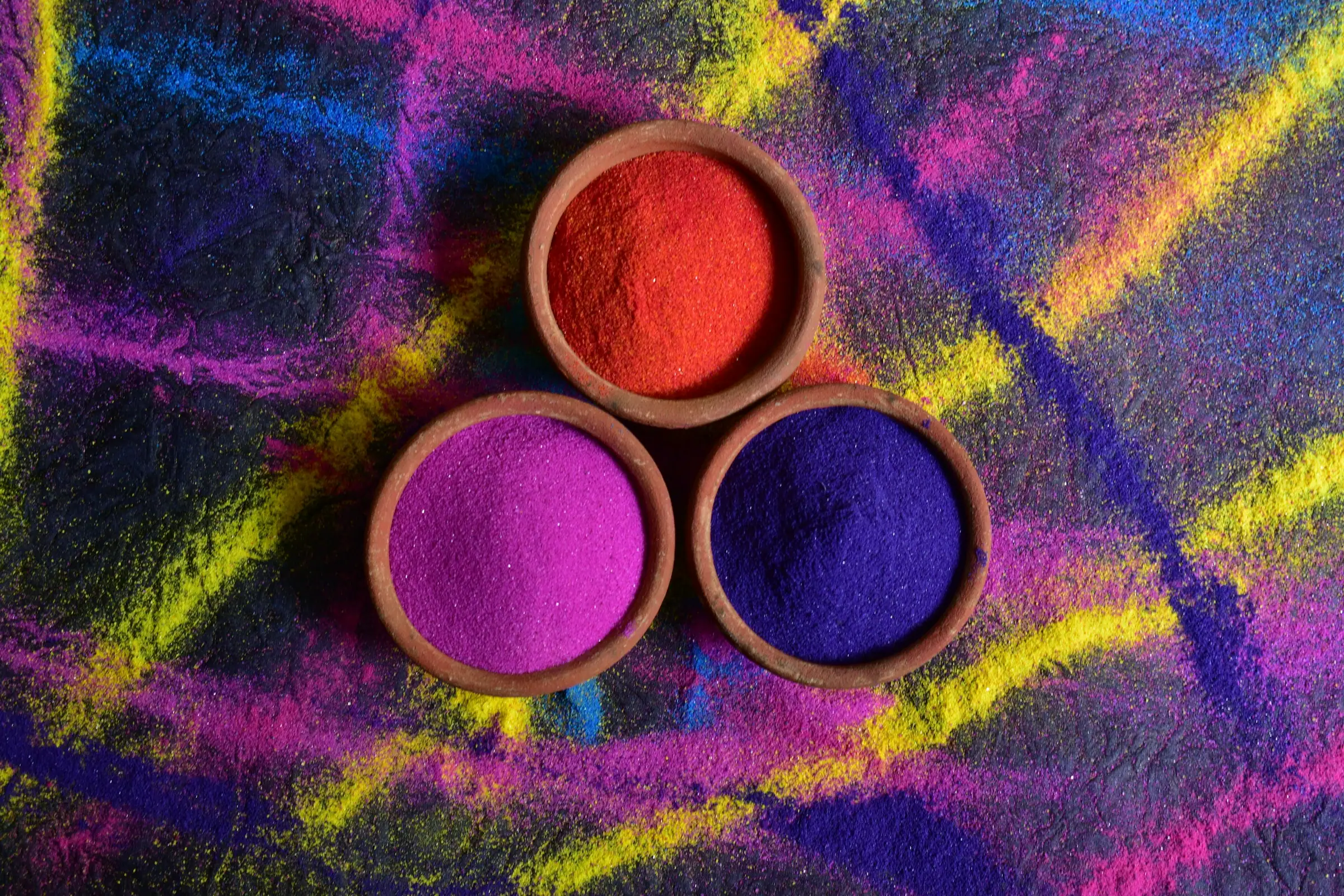Schalen mit farbigem Pulver für Holi