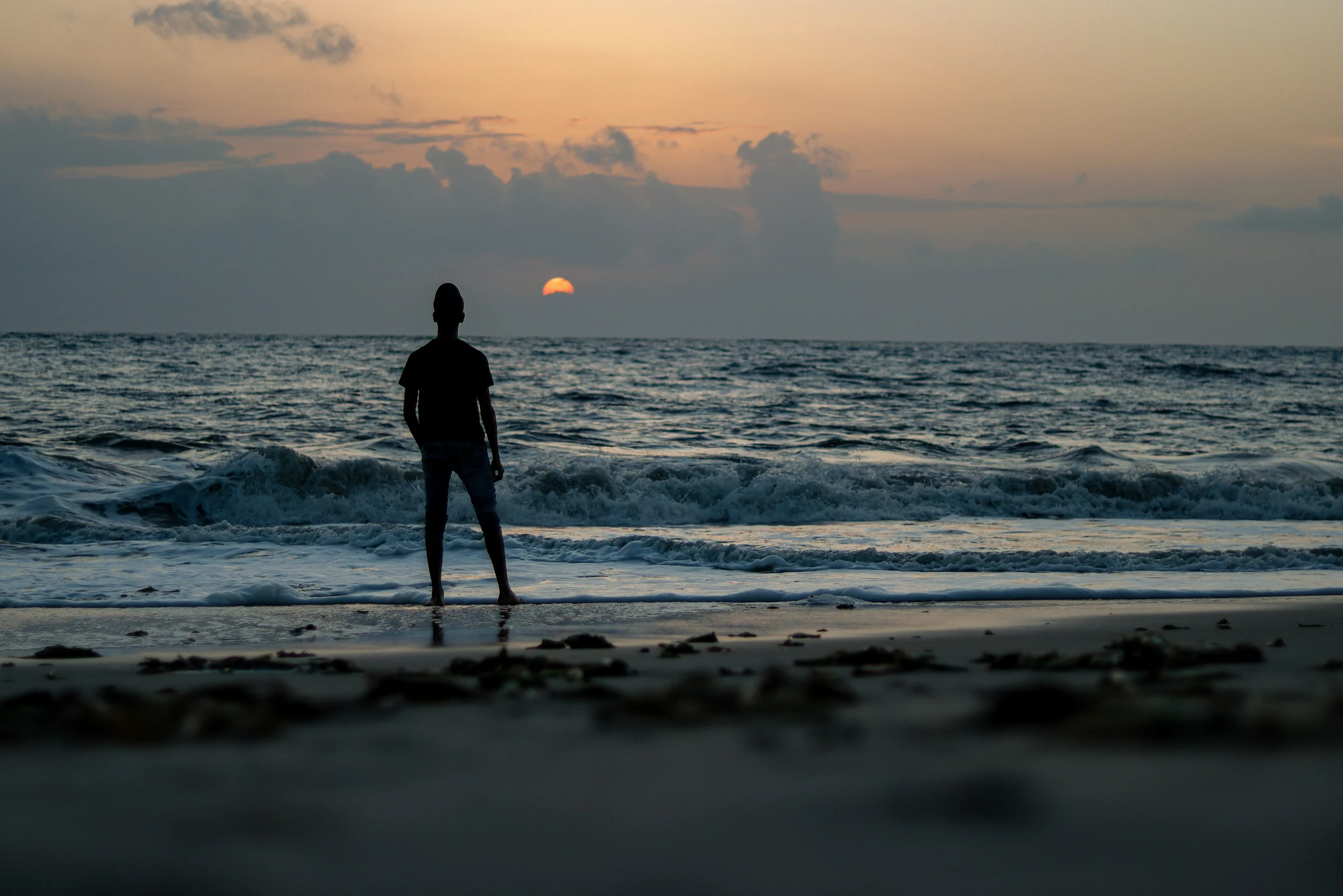 Eine Gestalt am Strand von Alappuzha bei Sonnenuntergang