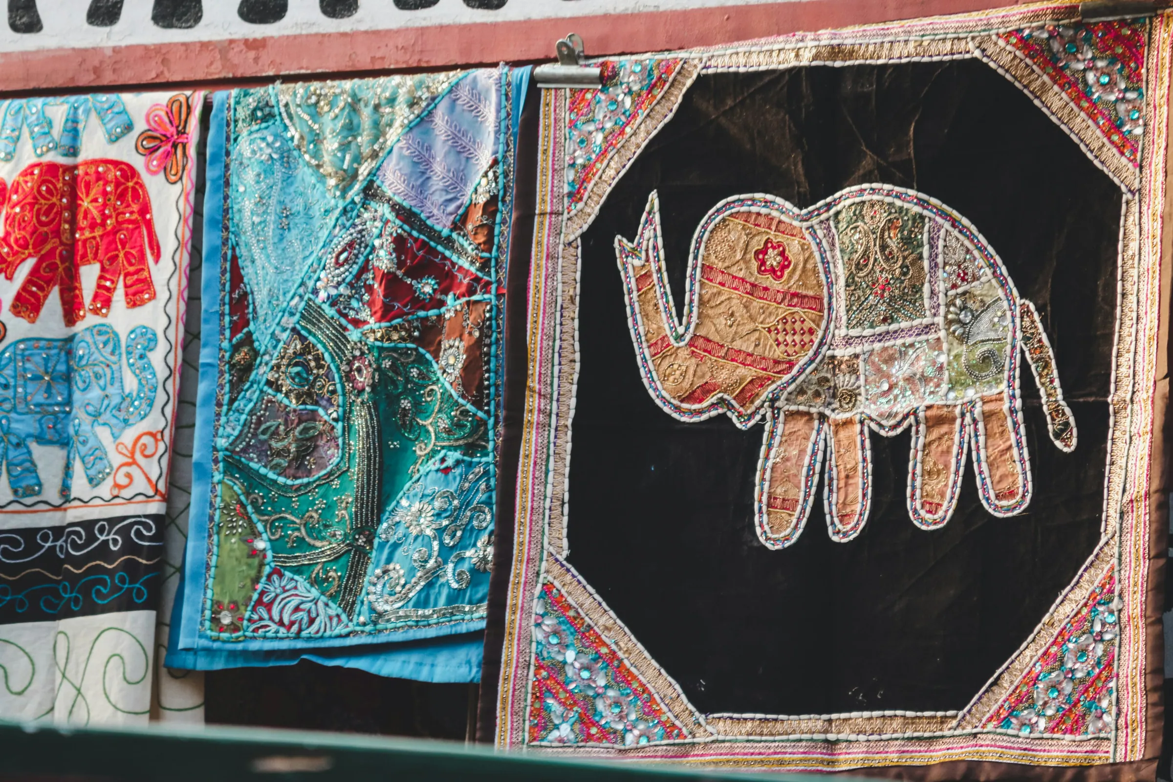 Bestickte und bedruckte Stoffe hängen auf einem Markt in Rajasthan