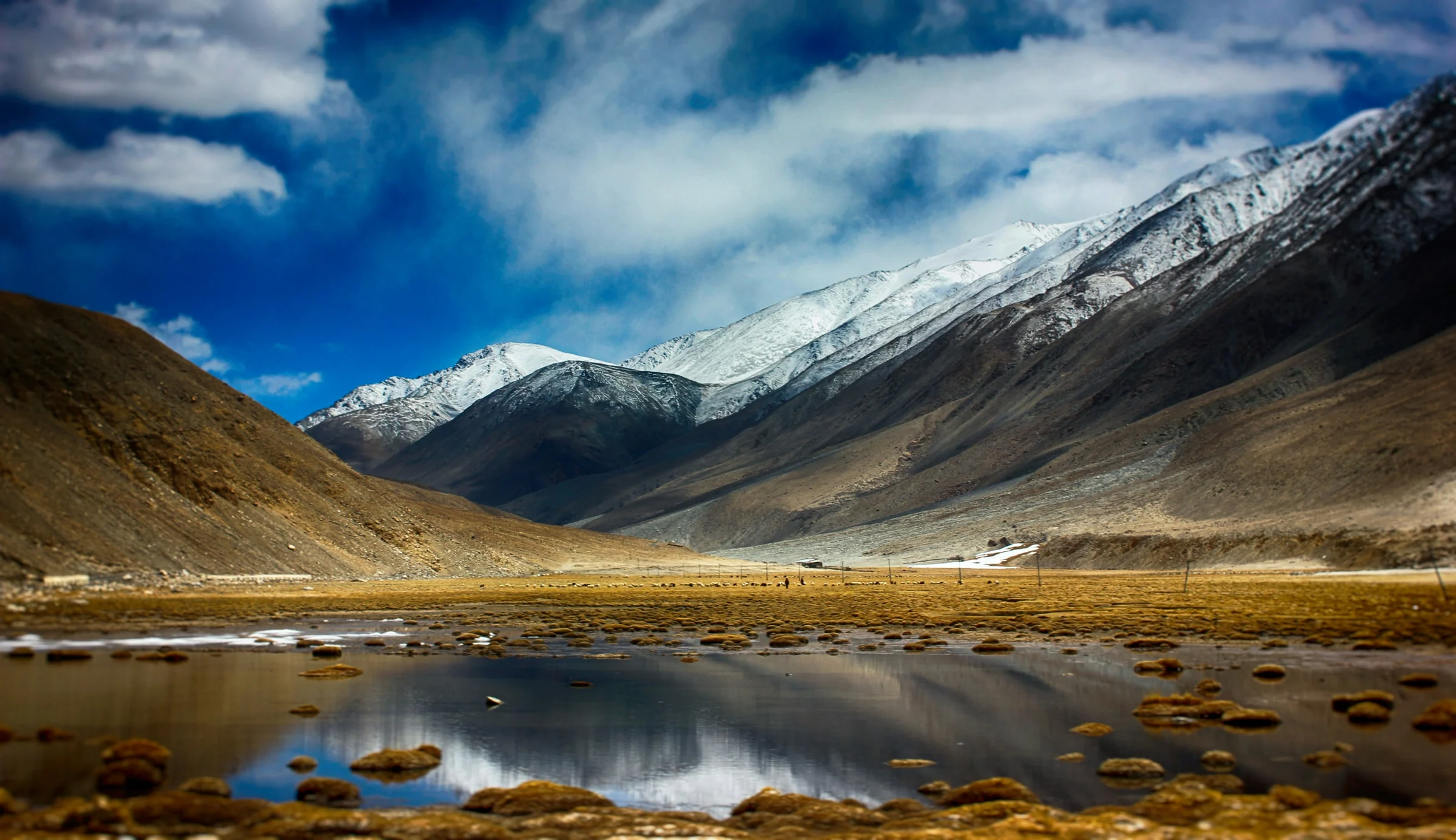Schnee auf den Bergen über einem Tal in Ladakh
