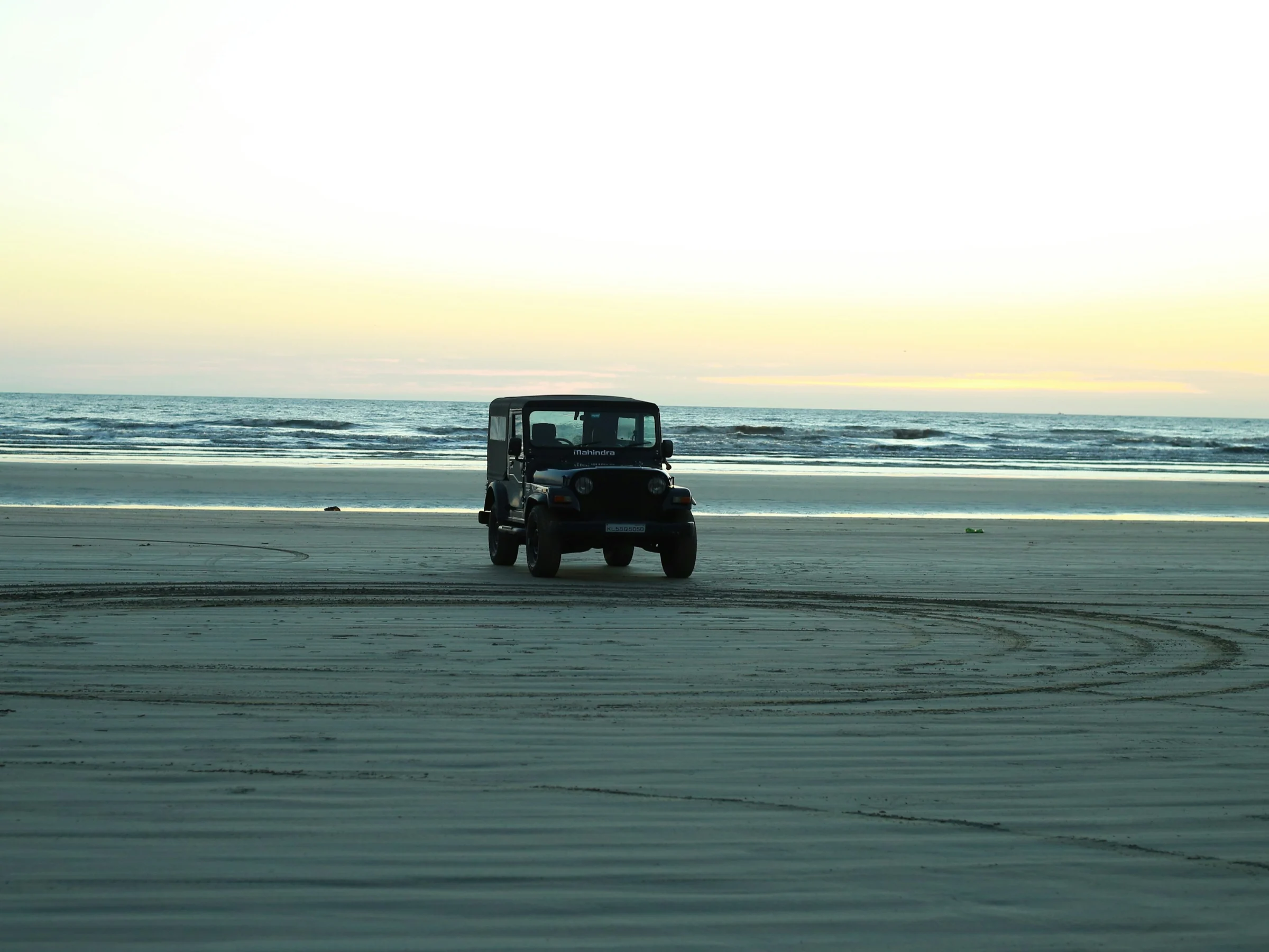 A jeep on the hard sand of the beach at Muzhappilangad